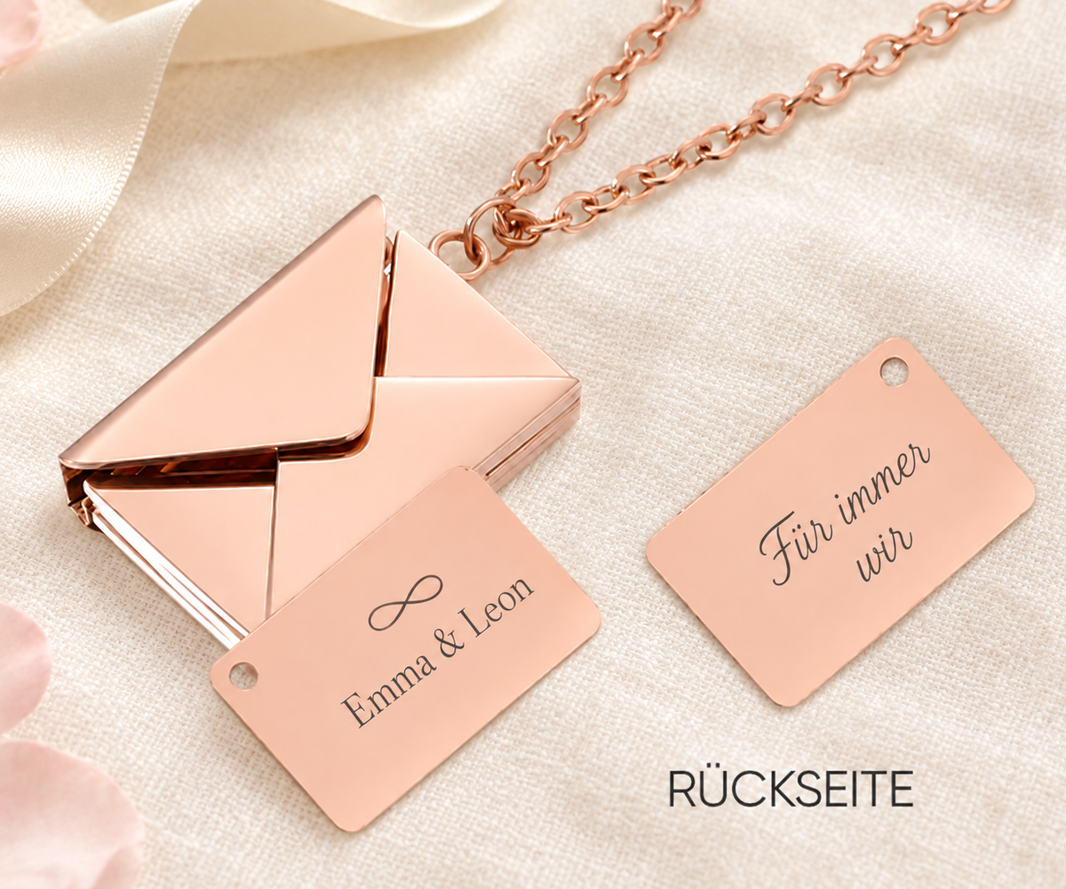 Roségoldfarbene Liebesbrief-Kette mit geöffnetem Umschlag und Gravur Emma & Leon mit Unendlichkeitszeichen auf hellem Leinen; daneben die Rückseite Für immer wir.